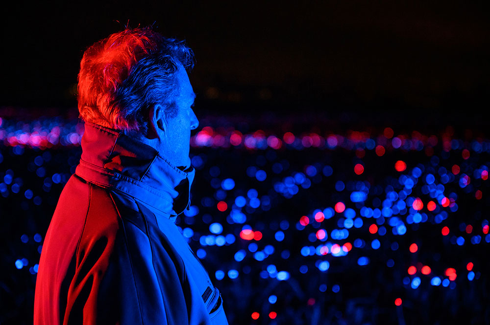 farmer standing in his illuminated field by Dutch artist designer Daan Roosegaarde.